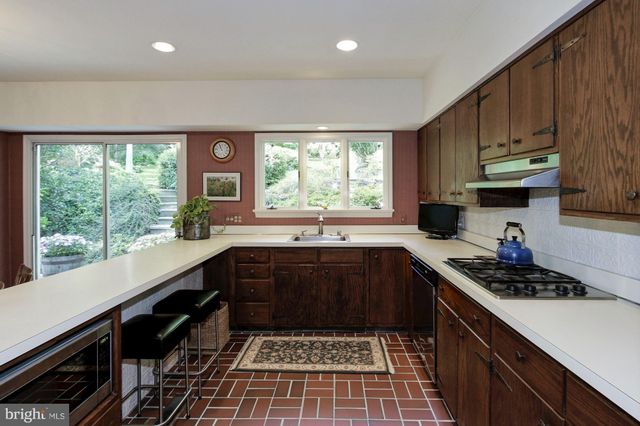 a kitchen with a sink a stove a cabinets and a window