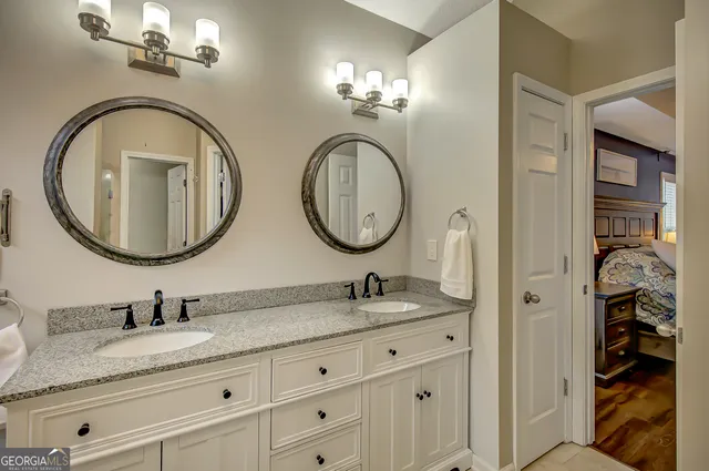 a bathroom with a granite countertop double vanity sinks and a mirror