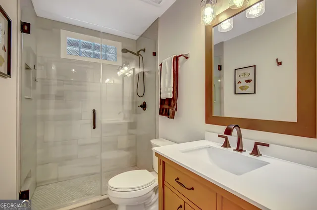 a bathroom with a sink toilet vanity and shower