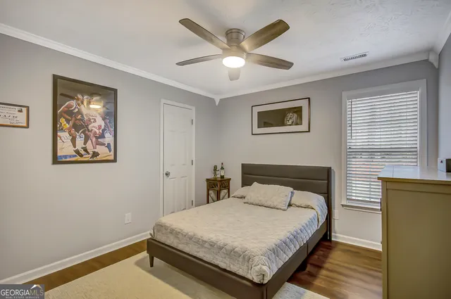 a bedroom with a bed and a painting on the wall