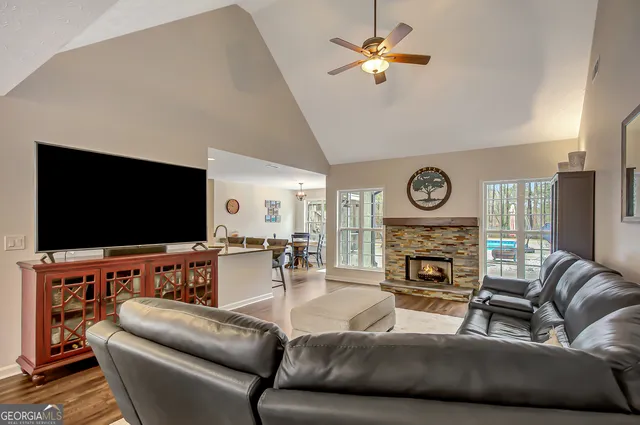 a living room with furniture a flat screen tv and a fireplace
