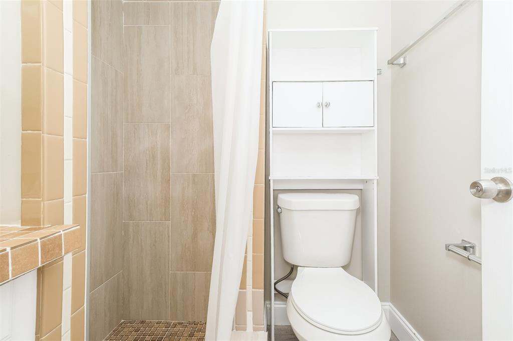 Undisclosed Address Clearwater, FL 33755 - Photo 11 of 15 a white toilet sitting next to a shower curtain