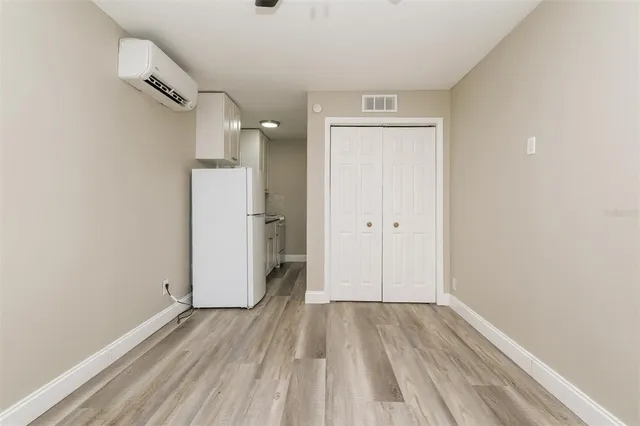 a view of a room with wooden floor and a bathroom
