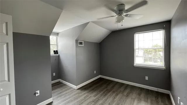 an empty room with windows and fan