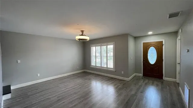 an empty room with wooden floor and window