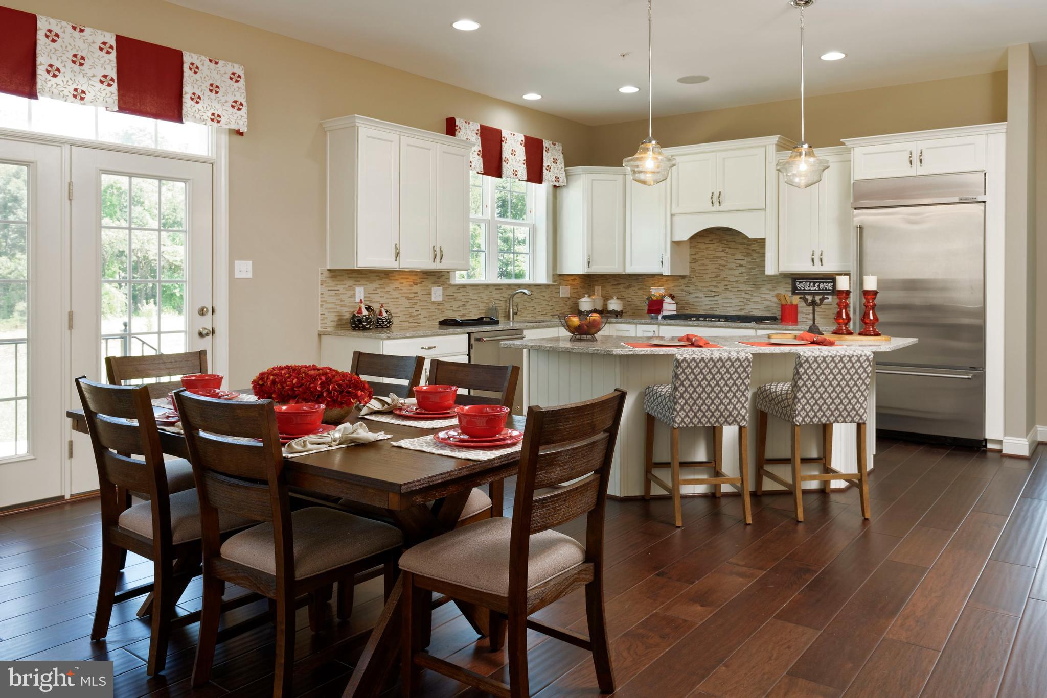 13044 Highland Road Highland, MD 20777 - Photo 10 of 11 a kitchen with a dining table chairs and white cabinets