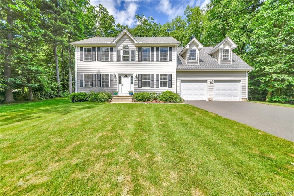 a front view of a house with a yard and green space