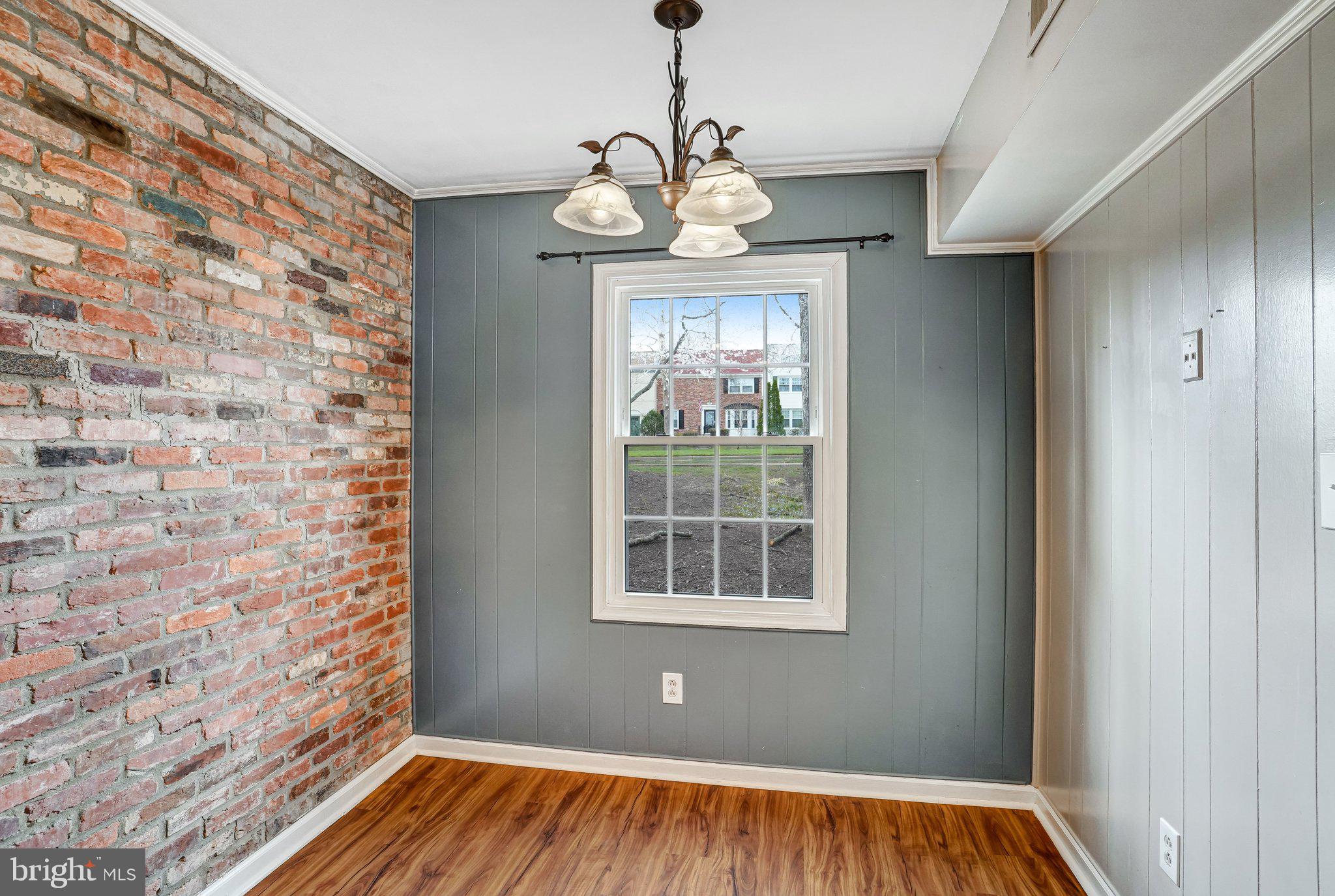 8396 Forrester Boulevard, Unit 555 Springfield, VA 22152 - Photo 6 of 24 a view of an empty room with a window and wooden floor