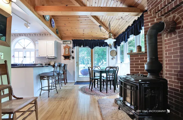 a dining room with wooden floor table and chairs