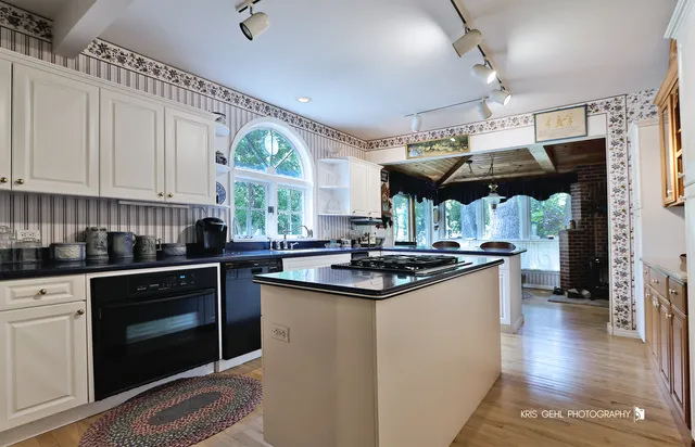 a kitchen with stainless steel appliances granite countertop a sink a stove and a wooden floors