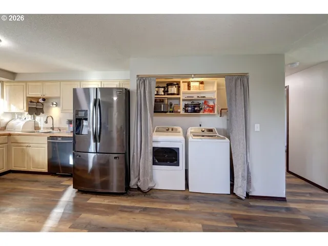 a view of a hallway with wooden floor and a living room