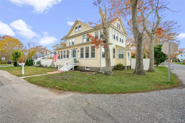 a front view of a house with a yard and trees
