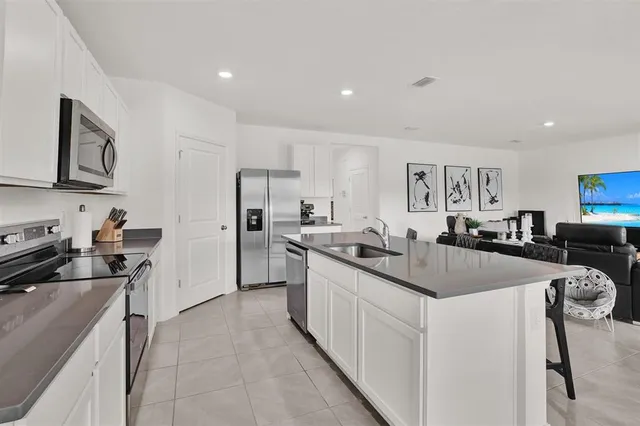 a kitchen with a sink stainless steel appliances and white cabinets