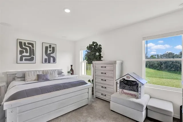 a bedroom with a bed a flat screen tv and a window