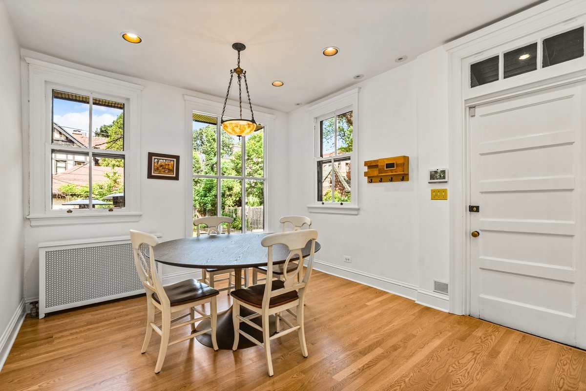 225 Hamilton Street Evanston, IL 60202 - Photo 12 of 38 a dining room with wooden floor a chandelier a wooden table and chairs
