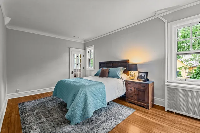 a bedroom with a bed and wooden floor