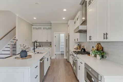 a kitchen with sink a stove and cabinets