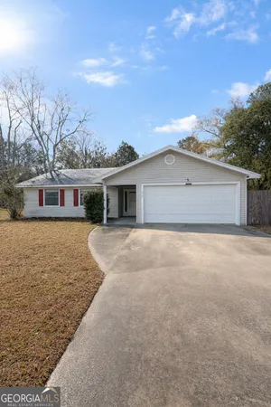 a front view of house with yard and trees around