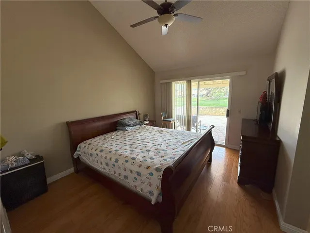 a bedroom with a bed and a flat tv screen on a dresser