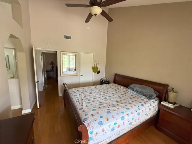 a bedroom with a bed and wooden floor