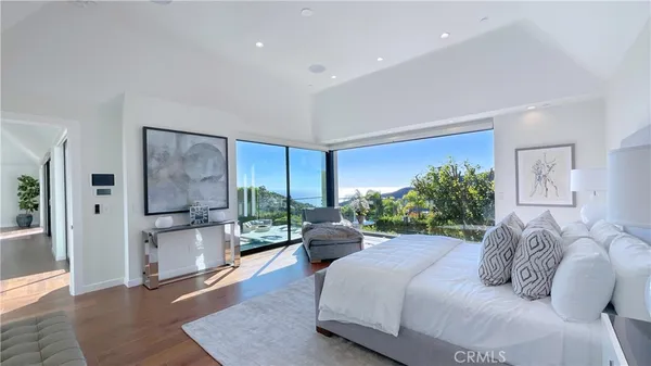 a bedroom with a balcony a bed and a large window
