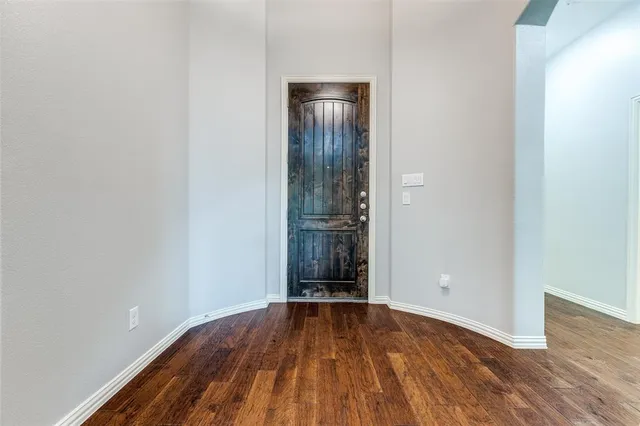 an empty room with wooden floor and entrance