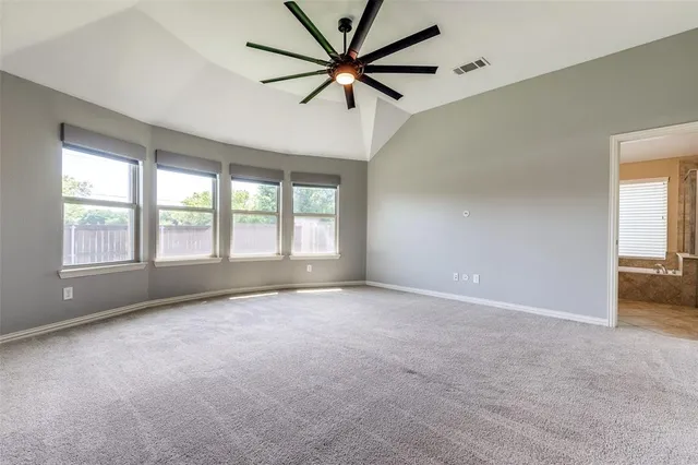 a view of an empty room with a window and a kitchen
