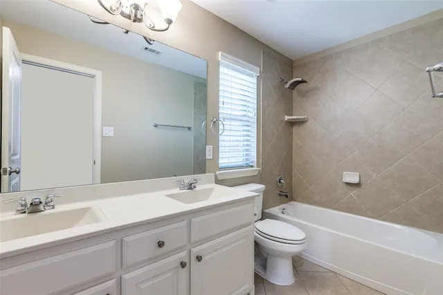 a bathroom with a double vanity sink toilet mirror and bathtub