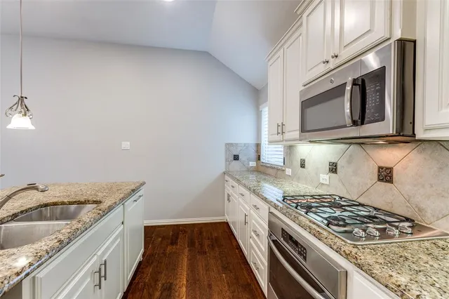 a kitchen with granite countertop a stove and a sink