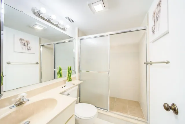 a bathroom with a granite countertop sink toilet and shower