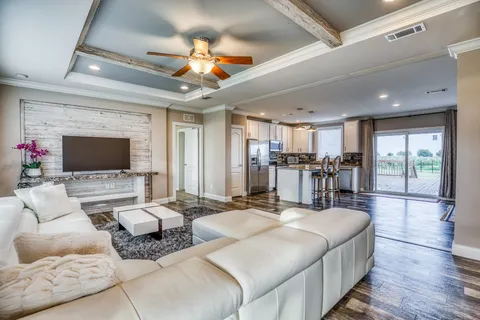 a kitchen with stainless steel appliances granite countertop a refrigerator a stove top oven and a dining table with wooden floor