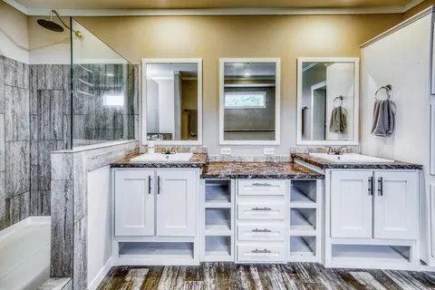 a large bathroom with a tub a double vanity sink and a large mirror