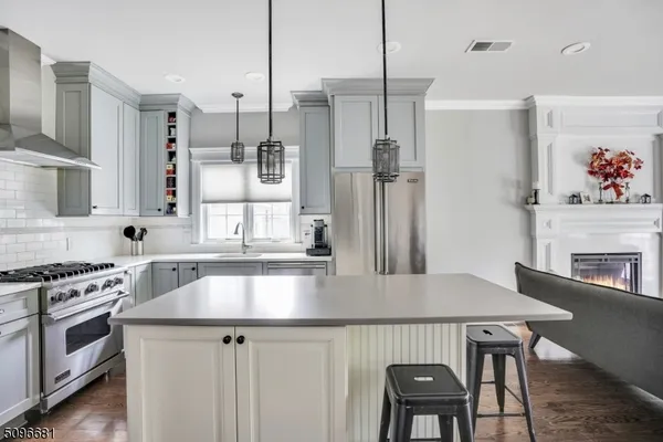 a kitchen with stainless steel appliances granite countertop a kitchen island a stove a table and chairs