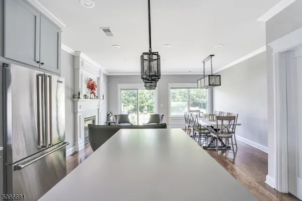 a kitchen with stainless steel appliances granite countertop a refrigerator and a view of living room