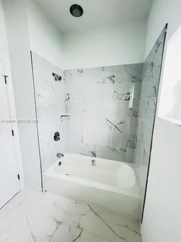 a white bath tub sitting next to a shower