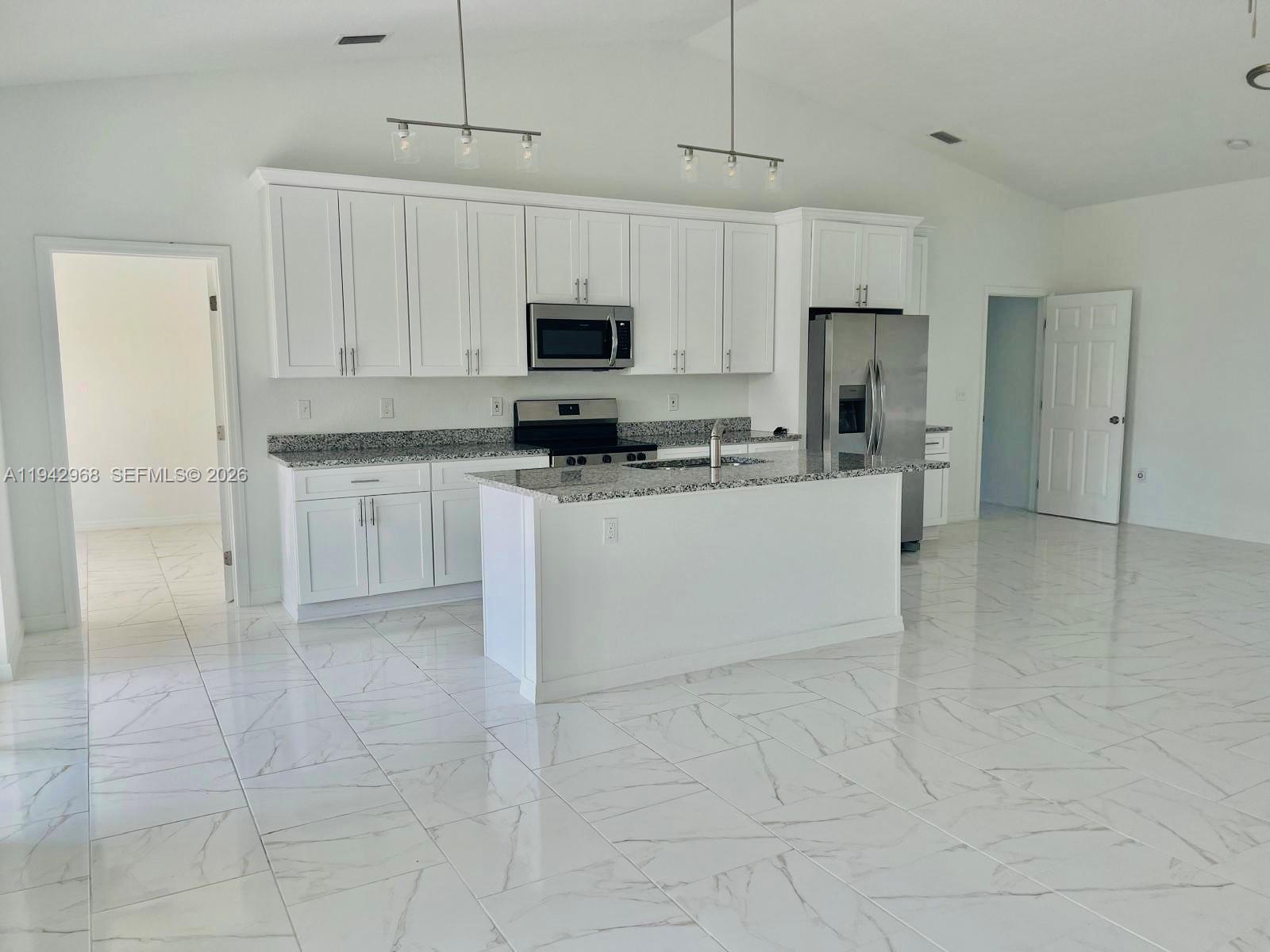 475 Sunset Road North Rotonda West, FL 33947 - Photo 4 of 17 a kitchen with stainless steel appliances a refrigerator sink and white cabinets