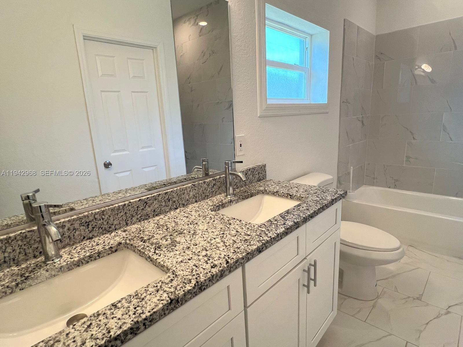 475 Sunset Road North Rotonda West, FL 33947 - Photo 9 of 17 a bathroom with a granite countertop sink and a mirror