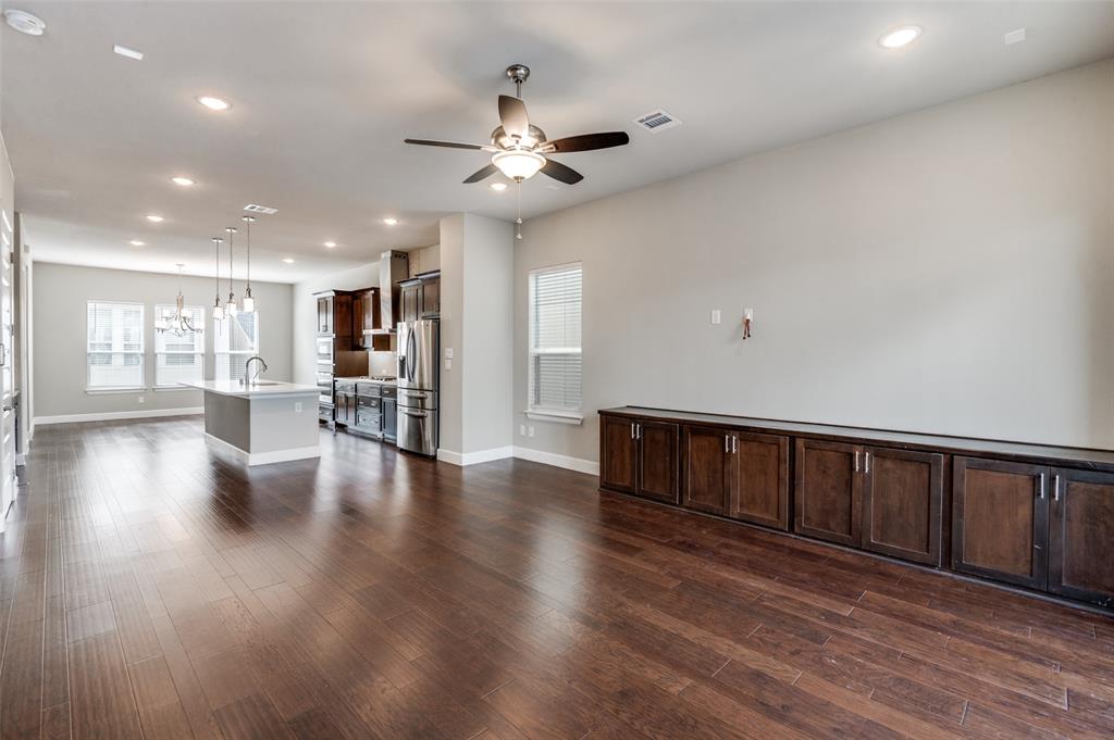 8233 Laflin Lane Dallas, TX 75231 - Photo 12 of 37 a view of an empty room with wooden floor and a kitchen