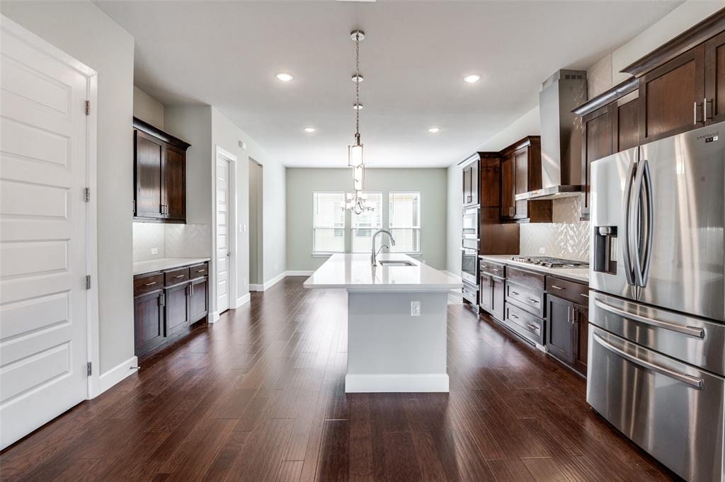 8233 Laflin Lane Dallas, TX 75231 - Photo 16 of 37 a kitchen with stainless steel appliances granite countertop a refrigerator a oven a stove and a wooden floors