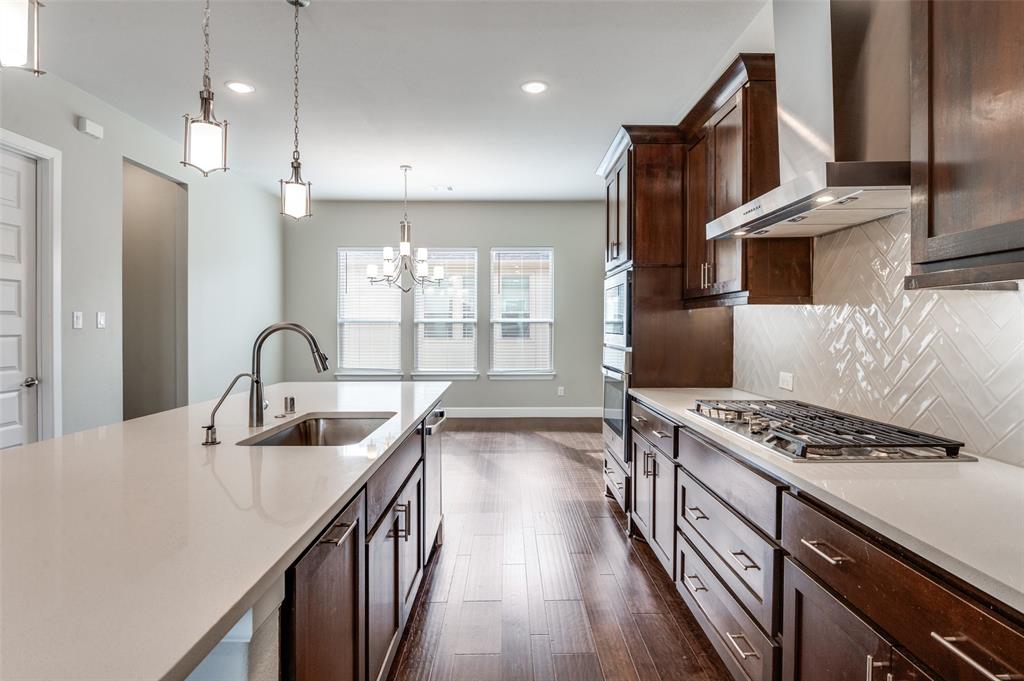 8233 Laflin Lane Dallas, TX 75231 - Photo 17 of 37 a kitchen with kitchen island stainless steel appliances a sink stove and cabinets