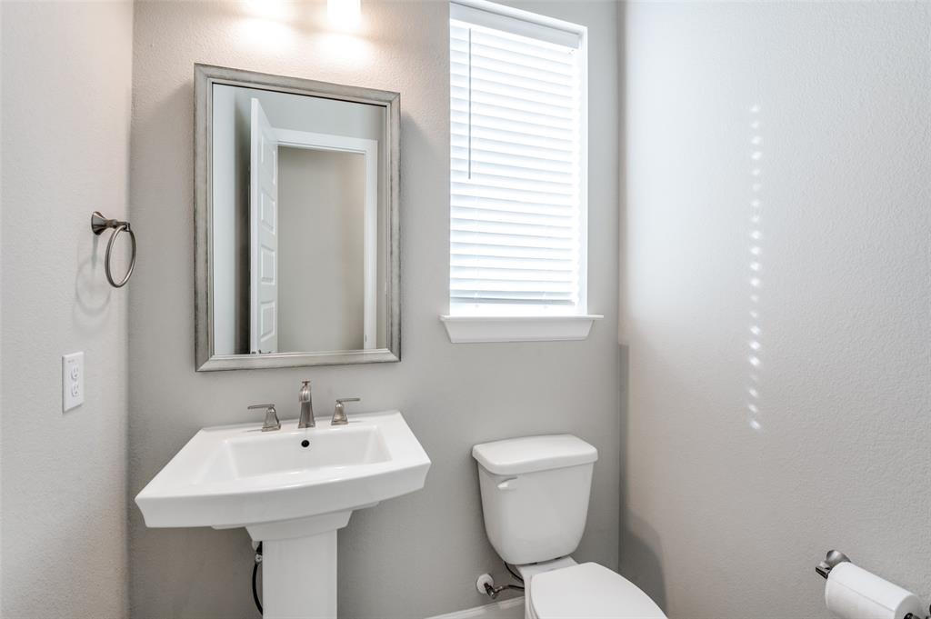 8233 Laflin Lane Dallas, TX 75231 - Photo 22 of 37 a bathroom with a toilet sink and mirror