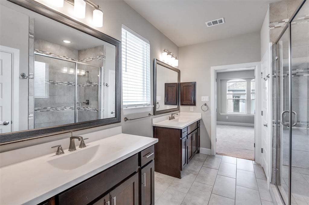8233 Laflin Lane Dallas, TX 75231 - Photo 27 of 37 a bathroom with a sink double vanity granite tub shower and a mirror