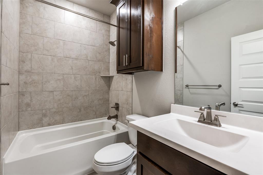 8233 Laflin Lane Dallas, TX 75231 - Photo 7 of 37 a bathroom with a toilet a sink and bathtub