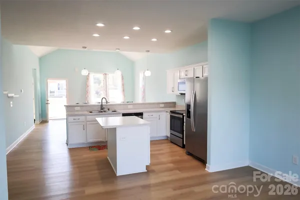 a kitchen with stainless steel appliances a refrigerator and a stove top oven