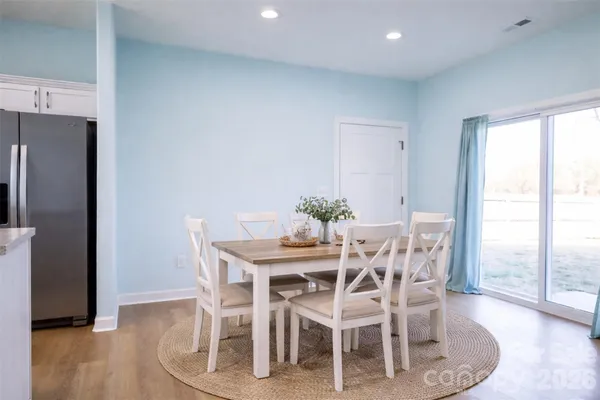 a dining room with furniture large window and wooden floor