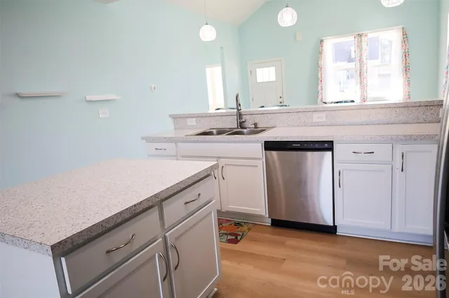a kitchen with a sink cabinets and wooden floor
