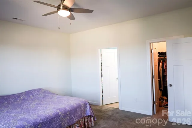 a bedroom with a bed and a chandelier fan