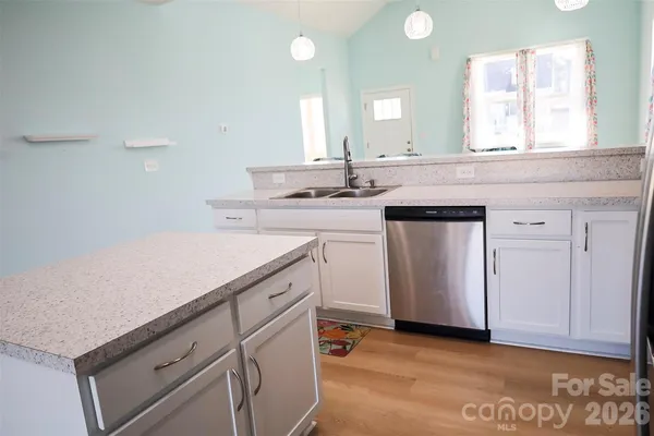 a kitchen with a sink cabinets and wooden floor
