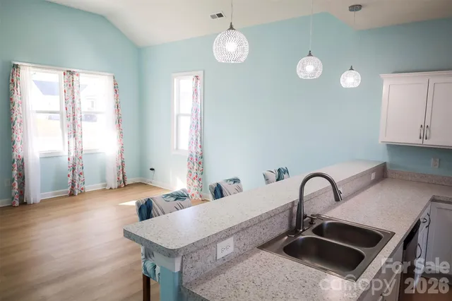 a kitchen with sink and view of living room