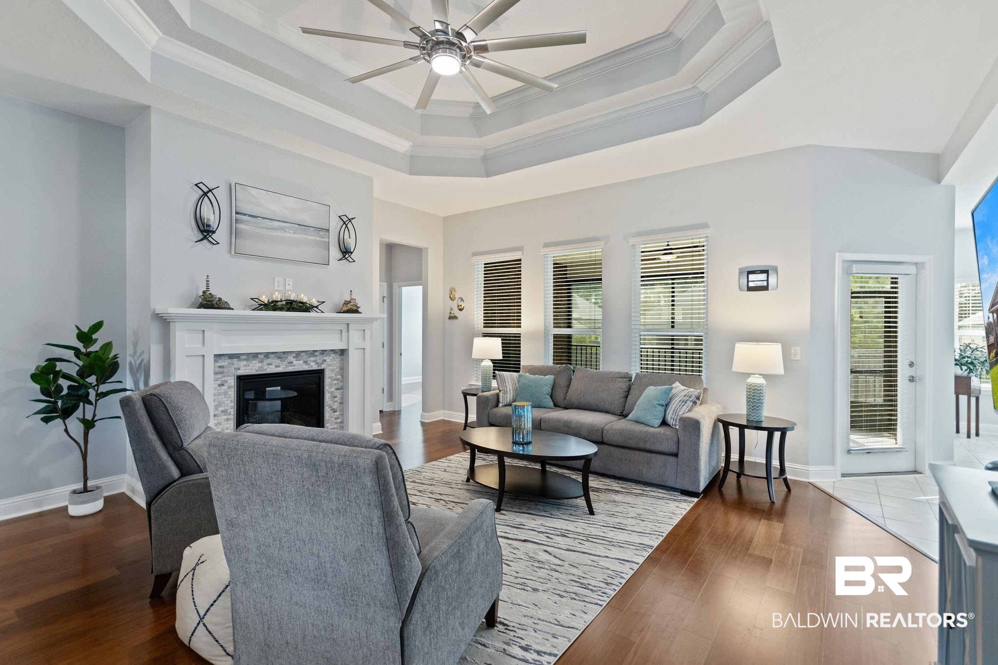 31541 Hoot Owl Road Daphne, AL 36527 - Photo 7 of 51 Living room featuring ceiling fan, a fireplace, a tray ceiling, and hardwood / wood-style floors